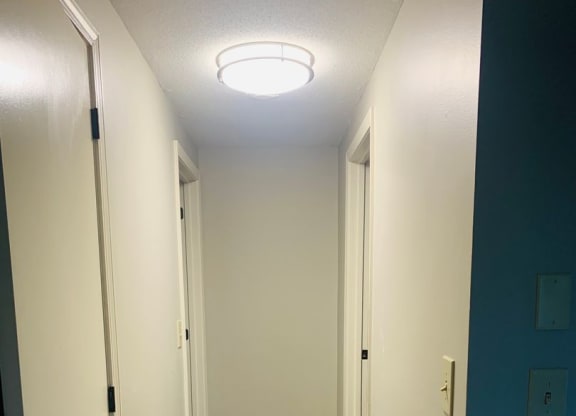 a hallway with wood flooring and a blue door at Briarcliff at Quechee, Quechee