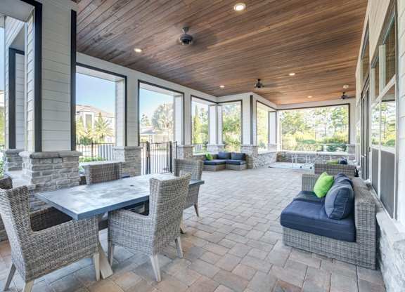 A patio with a table and chairs is surrounded by a stone wall.at Century Ariva, Lakeland, Florida