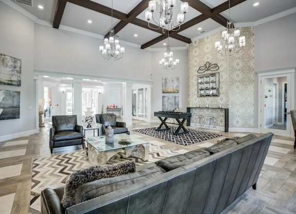 A large, modern living room with a dark leather couch and a fireplace.at Century Ariva, Lakeland, Florida