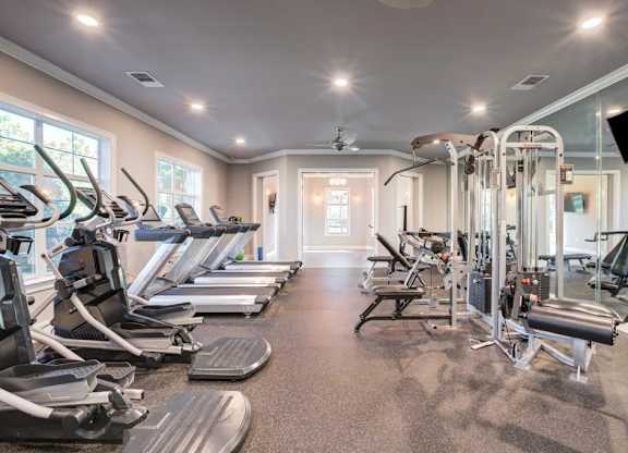 A well-lit gym with treadmills, elliptical machines, and other exercise equipment.at Century Ariva, Lakeland, 33812
