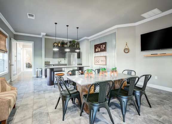 A dining room with a table set for six and a television mounted on the wall.at Century Ariva, Florida