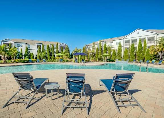 A pool surrounded by chairs and trees with a building in the background.at Century Ariva, Florida, 33812
