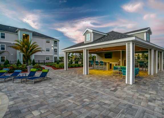 A patio area with a gazebo and chairs is surrounded by apartment buildings.at Century Ariva, Lakeland Florida