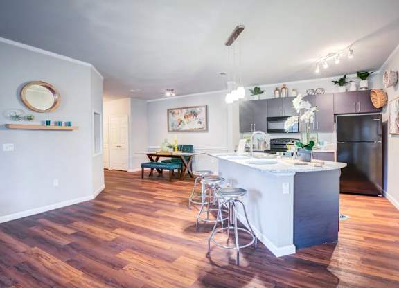 A kitchen with a white island and a bar stool.at Century Ariva, Lakeland