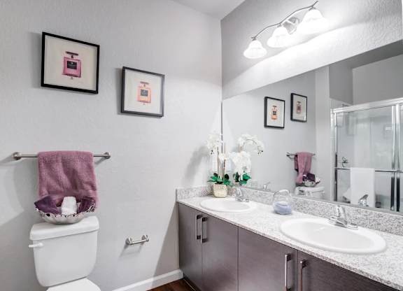 A bathroom with a toilet, sink, and towel rack.at Century Ariva, Lakeland, FL 33812