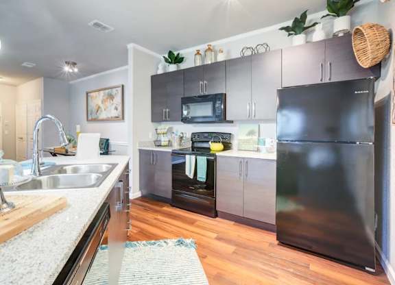 A modern kitchen with a black refrigerator and stove.at Century Ariva, Florida, 33812
