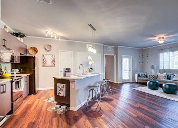A kitchen with a white island and a dining area with a white table and chairs.at Century Ariva, Lakeland, Florida