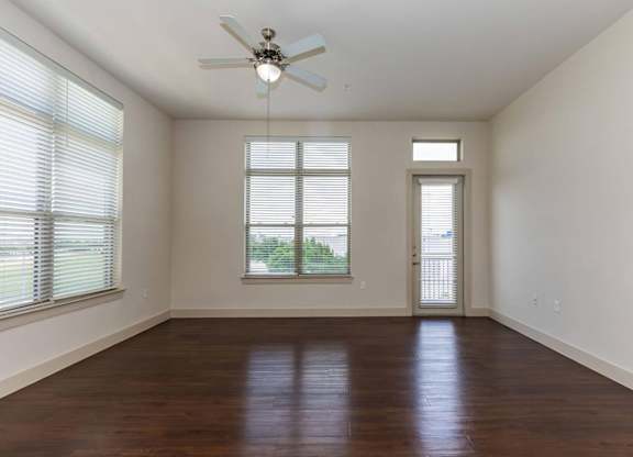 A room with a ceiling fan and wooden flooring.at Century Cedar Hill, Cedar Hill