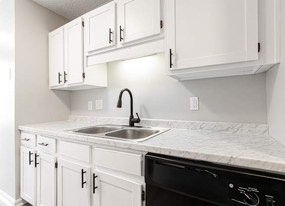 Compact kitchen with white cabinetry and marble countertops at Salem Glen Apartments, Georgia