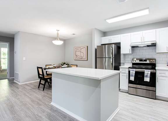 A kitchen with a white island and stainless steel appliances at Keita 1875, College Park
