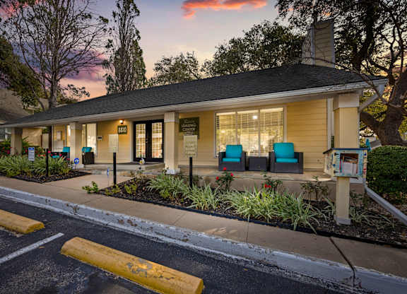 A building with a porch and a mailbox in front of it.