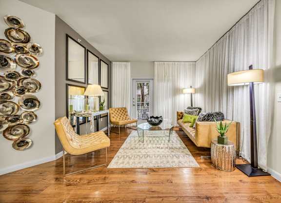 A living room with a yellow chair and a glass table.