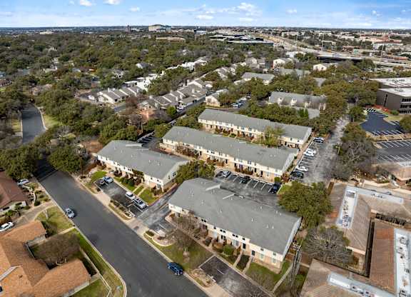 A road runs through a residential area with houses on either side.