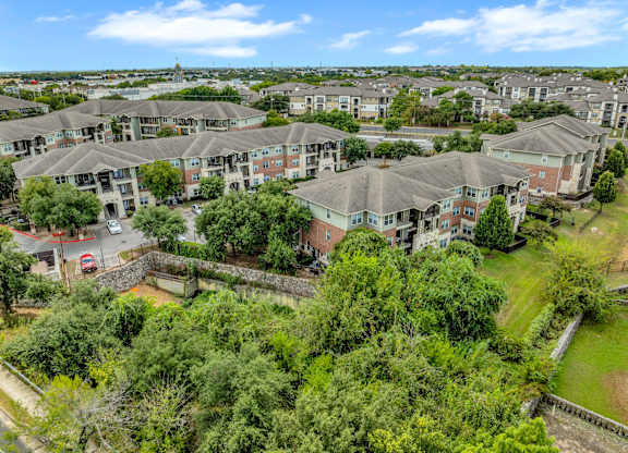A bird's eye view of a residential area with houses and greenery.