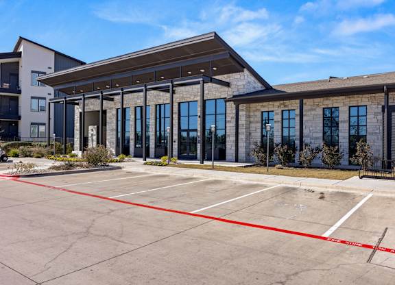 A parking lot with a building in the background. at Bridge at Tech Crossing, Austin, TX, 78753