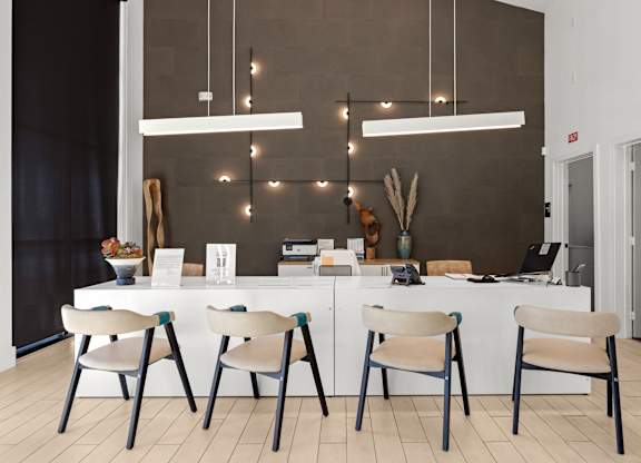 A modern kitchen with a white table and chairs. at Bridge at Tech Crossing, Texas