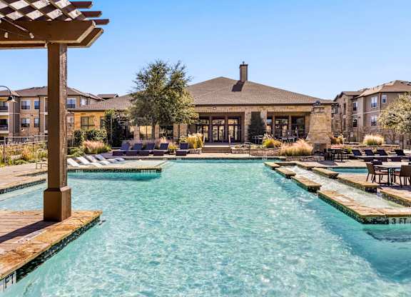 A large swimming pool with a wooden pergola over it. at The Royce at 8100, Texas, 78729