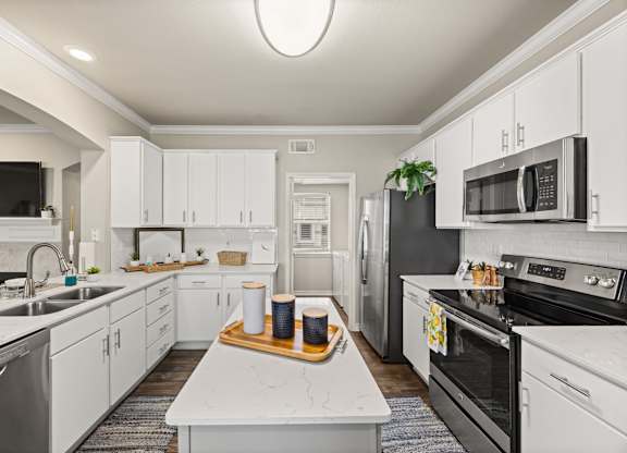 A modern kitchen with white cabinets and stainless steel appliances. at Bridge at Canyon Creek, Austin, 78726