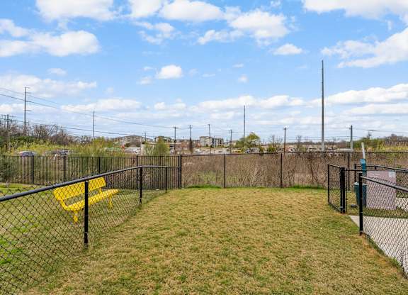 A black fenced area with a yellow bench and a tall pole.