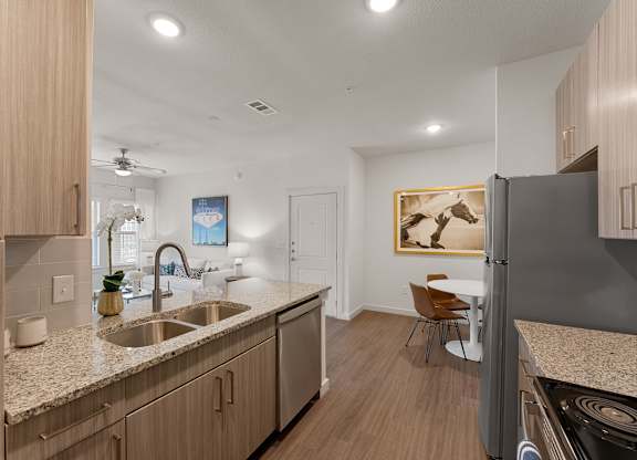A modern kitchen with wooden cabinets and a granite countertop.