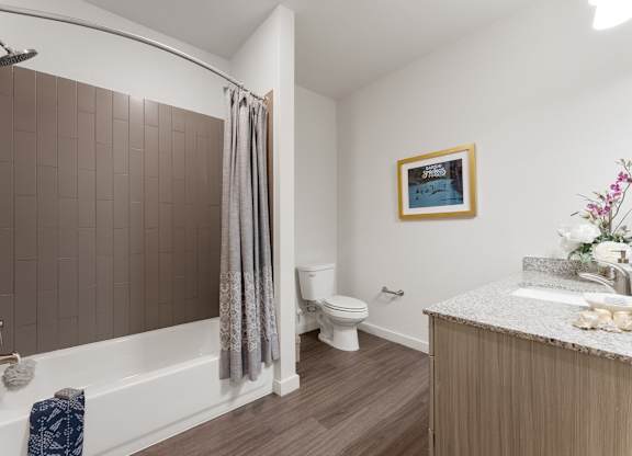 A bathroom with a white tub, toilet, and sink.