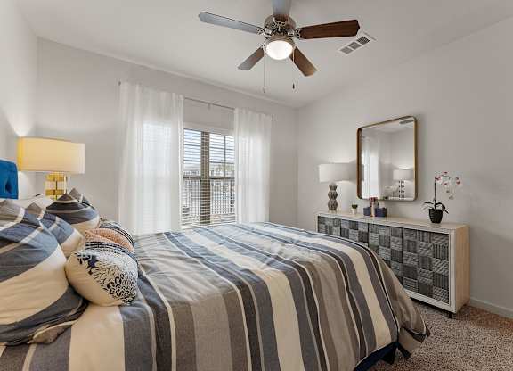 A bedroom with a bed, a dresser, and a mirror.