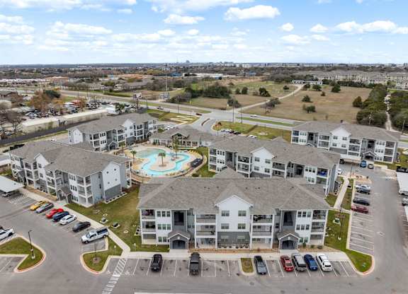 A large apartment complex with a pool in the middle.