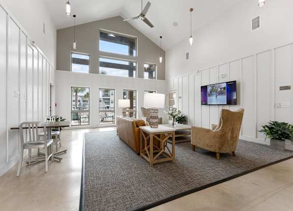 A living room with a grey rug and a wooden table.