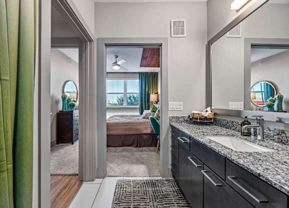 A bathroom with a green curtain and a mirror above the sink. at Bridge at Henley, Texas