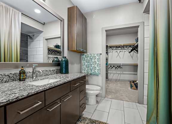 A bathroom with a sink, mirror, and toilet. at Bridge at Henley, Austin, TX, 78741
