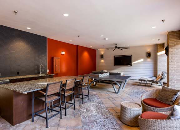 A modern kitchen with a bar area and seating. at Bridge at Henley, Austin, TX