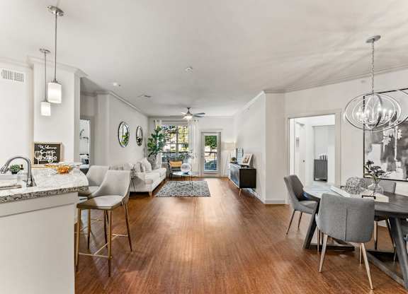 A modern kitchen with a dining area and a living room. at Bridge at Indigo, Austin, Texas