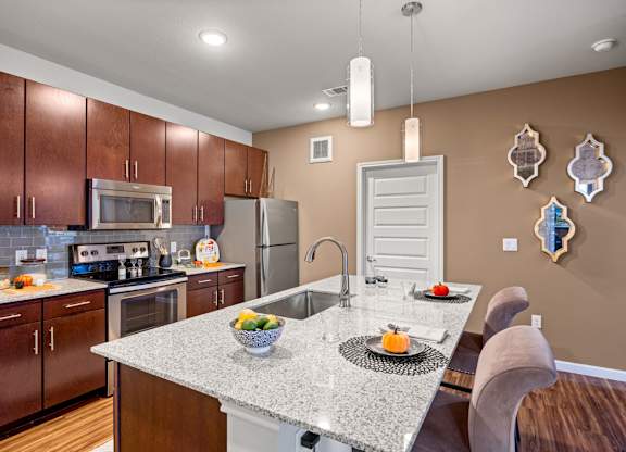A kitchen with brown cabinets and a granite countertop. at Bridge at Southpark Meadows, Texas, 78748
