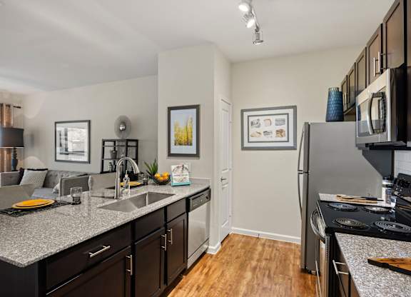 A kitchen with a refrigerator, microwave, and oven. at Bridge at Southpark Meadows, Austin, Texas