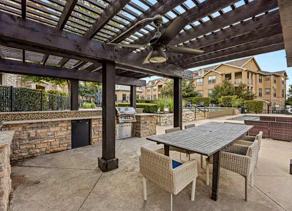A patio with a table and chairs under a pergola. at The James on South First, Austin, 78748