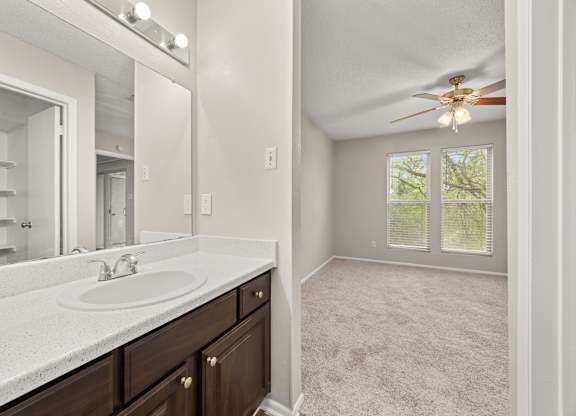 A bathroom with a sink, mirror, and a ceiling fan. at Montecito, Texas
