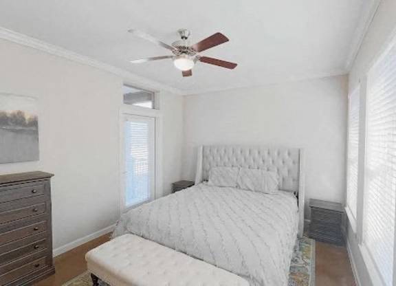 A bedroom with a bed, dresser, and window. at Bridge at Heritage Woods, Austin, TX, 78753