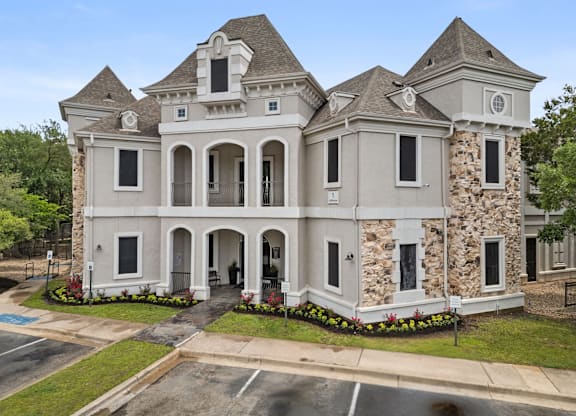 A large, two-story house with a stone facade and a grey roof. at Bridge at Canyon Creek, Austin, 78726