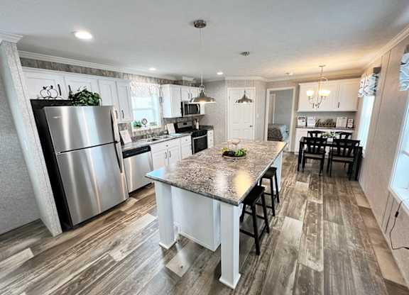 a kitchen with a large island and stainless steel appliances