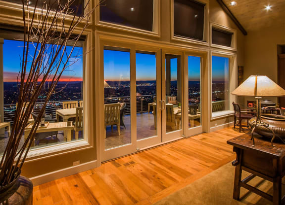 a living room with large windows and a view of the city at night