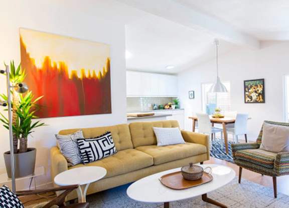 a living room with a yellow couch and two chairs