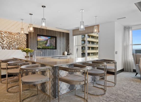 a kitchen with bar stools and a dining table
