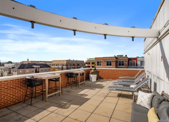 a patio with tables and chairs on a roof top