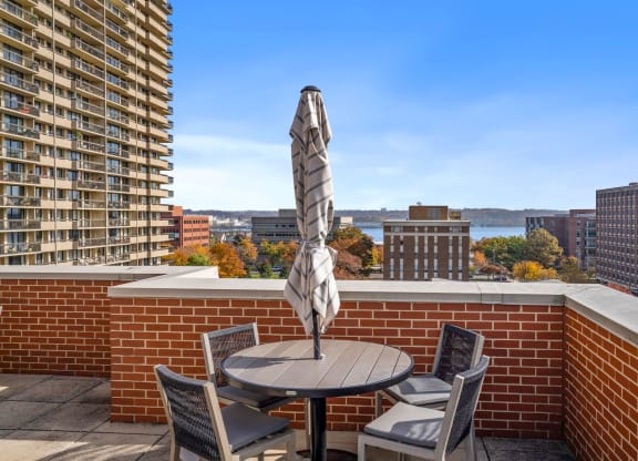 a balcony with a table and chairs and a view of the city