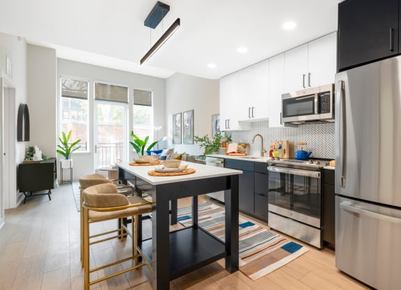 a kitchen with stainless steel appliances and a table with chairs
