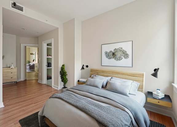 A bedroom with a large bed and a painting on the wall.