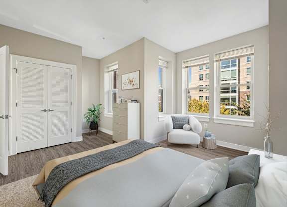 A bedroom with a large bed and a window overlooking a cityscape.