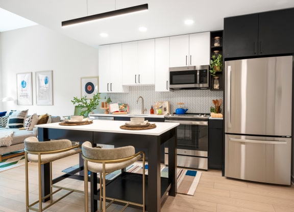 a kitchen and dining room with stainless steel appliances and a table and chairs