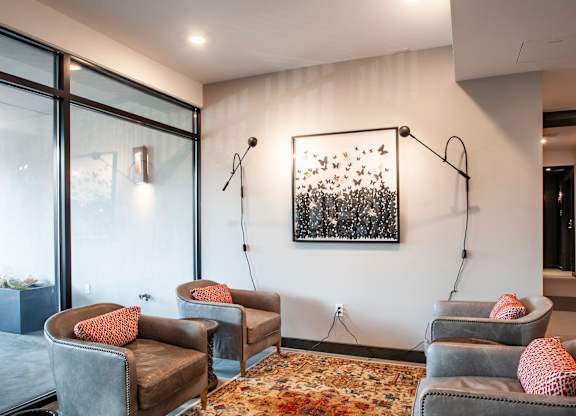 A room with grey couches and a painting on the wall.