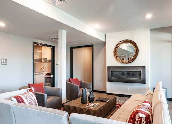 A modern living room with a fireplace and a large mirror on the wall.